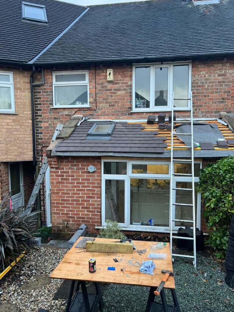 This is a photo of a roof extension that is having new roof tiles installed. This is a photo taken from the roof ridge looking down a tiled pitched roof on to a flat roof. Works carried out by South Wigston Roofing Repairs