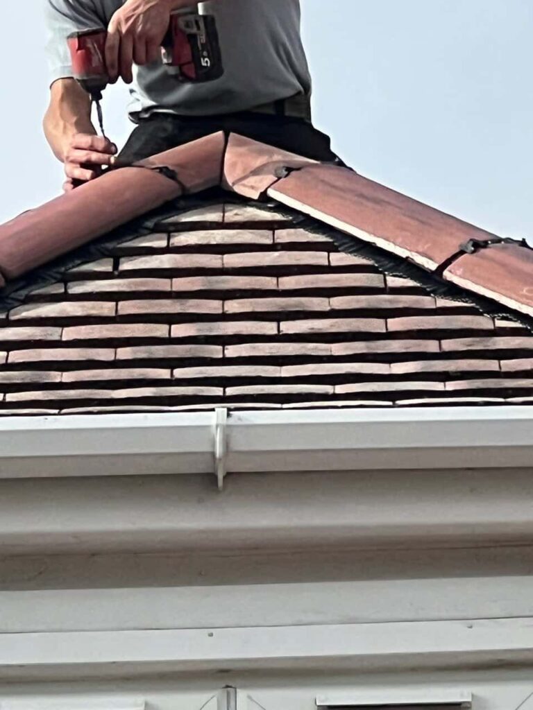 This is a photo of one of the operatives of South Wigston Roofing Repairs installing new ridge tiles